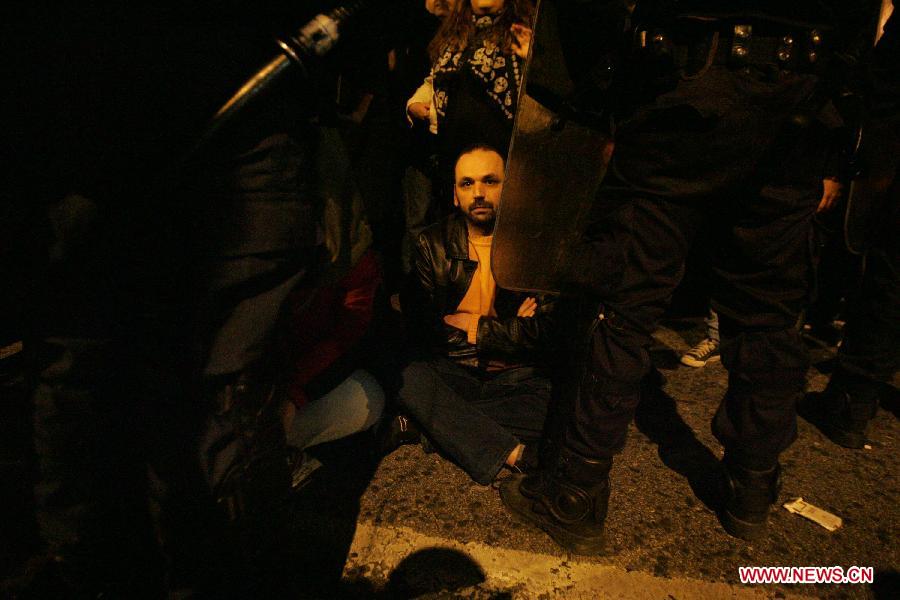 Greek indignant protesters clash with riot police in front of the Parliament in the Greek capital of Athens on March 10, 2013. About 500 indignant protesters come to Syntagma square to protest the harsh and painful austerity measures carried out by the government to counter debt crisis. (Xinhua/Marios Lolos) 