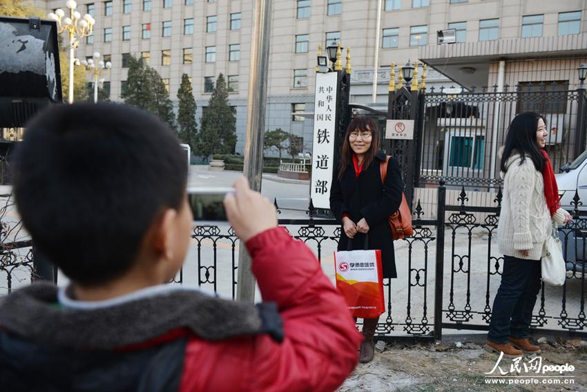 People take photos in front of the gate of the Ministry of Railways on March 11, 2013 as China plans to split it up into administrative and commercial branches in order to reduce bureaucracy and improve railway service efficiency.(Photo/People's Daily Online)