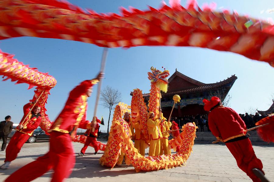 Folk artists play dragon dance during a ceremony in Binzhou City, east China's Shandong Province, March 13, 2013, on the occasion of the second day of the second lunar month, known in Chinese as Er Yue Er, "a time for the dragon to raise its head", as a Chinese saying goes. Various kinds of traditional activities were held all over the country to celebrate the festival to pray for a good harvest in the coming year. (Xinhua/Li Zhenping)