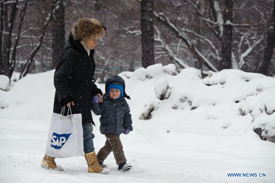 People walk during a snowfall in Moscow, Russia, March 14, 2013. A rare heavy snowfall hit Moscow on Wednesday and Thursday, causing traffic jams and disturbing scheduled flights. (Xinhua/Jiang Kehong) 