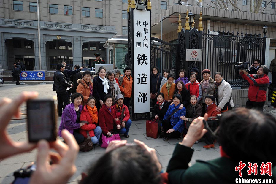 Nostalgic residents line up outside the headquarters of the Ministry of Railway to take photos with its sign yesterday afternoon. On the day, the first session of the 12th NPC endorsed the government restructuring plan, according to which the Ministry of Railway would be dissolved.（Photo/Chinanews.com）