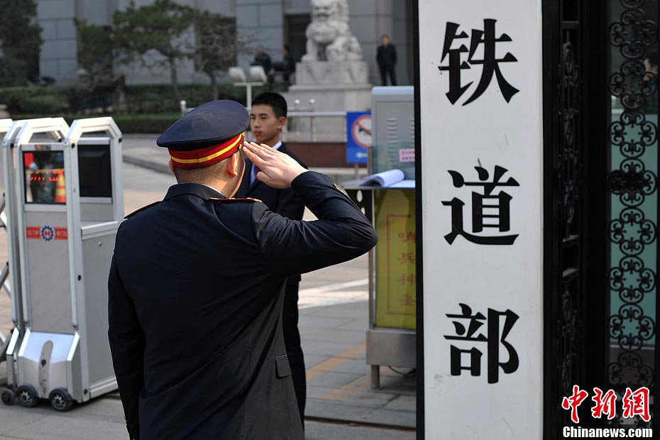 Nostalgic residents line up outside the headquarters of the Ministry of Railway to take photos with its sign yesterday afternoon. On the day, the first session of the 12th NPC endorsed the government restructuring plan, according to which the Ministry of Railway would be dissolved.（Photo/Chinanews.com）