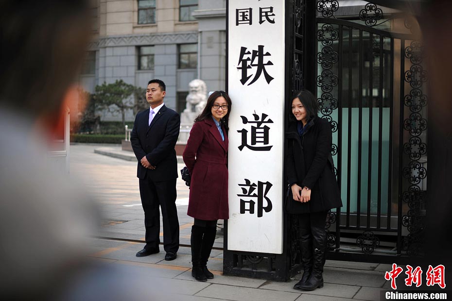 Nostalgic residents line up outside the headquarters of the Ministry of Railway to take photos with its sign yesterday afternoon. On the day, the first session of the 12th NPC endorsed the government restructuring plan, according to which the Ministry of Railway would be dissolved.（Photo/Chinanews.com）