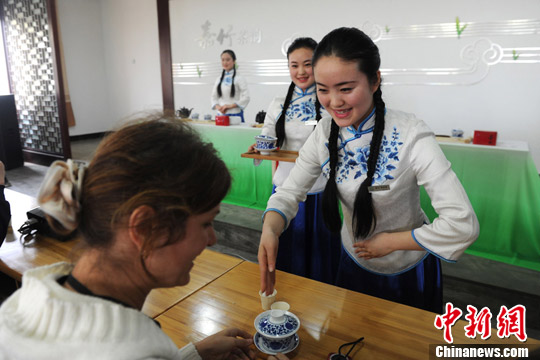 Triplet sisters Zhou Shuangxue, Zhou Shuangjie and Zhou Shuangdi provide a wonderful tea ceremony to foreign guests on the fourth China Tea Festival held Sunday in Pujiang County, Sichuan province.(Photo source: Chinanews.com/ Zhang Lang)