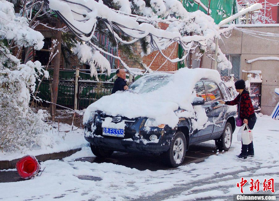 Buildings and streets are covered by thick snow, Beijing, March 20, 2013. A cold front brought rain and heavy snow to most parts of Beijing on Tuesday and temperature dropped dramatically below freezing at night, a sharp contrast to Monday which experienced a warm and comfortable early spring day. (Photo/Chinanews.com)