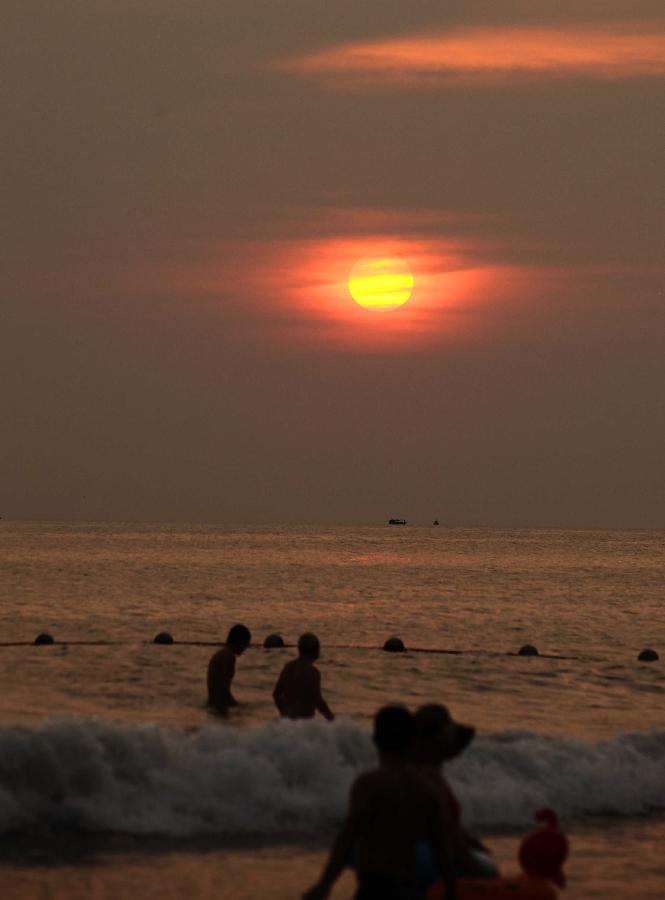 Visitors swim in the sea in Sanya, a tourist destination in south China's Hainan Province, March 20, 2013. (Xinhua/Chen Wenwu) 