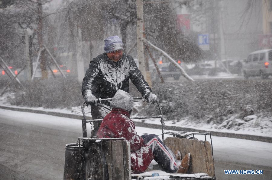 Citizens ride in snow in Jilin City, northeast China's Jilin Province, March 27, 2013. (Xinhua/Wang Mingming)