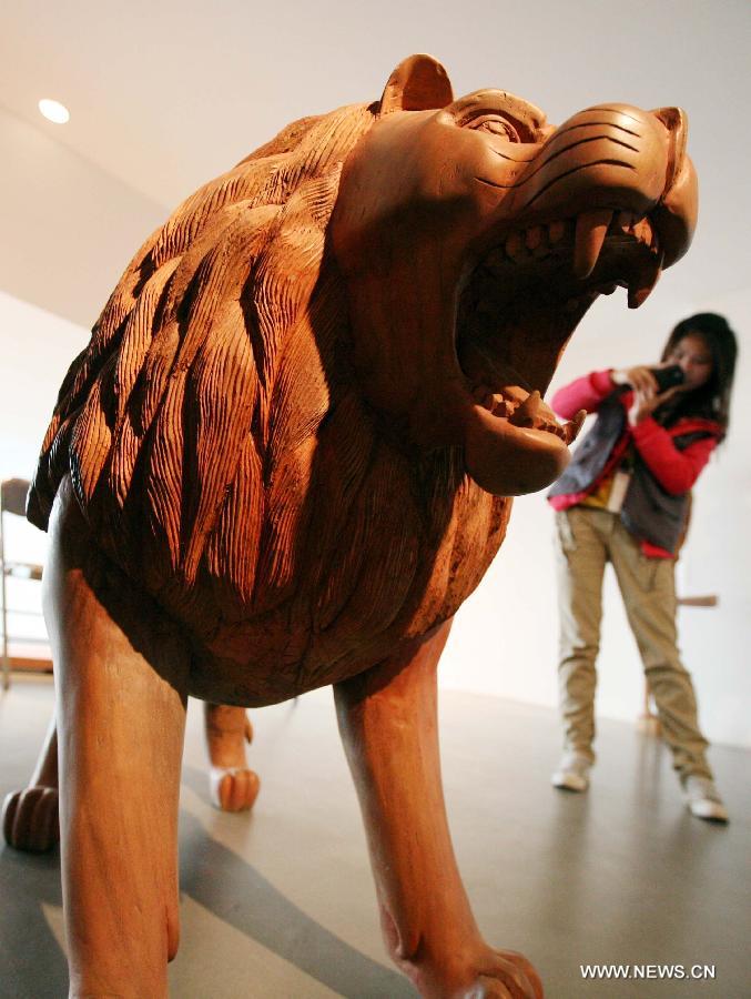 A visitor views a wood sculpture at the African Wood Sculpture Collection exhibition in Nanjing, capital of east China's Jiangsu Province, March 29, 2013. The exhibition kicking off on Friday displays near 600 wood carving works from dozens of countries in the sub-Saharan Africa. (Xinhua/Wang Xin) 