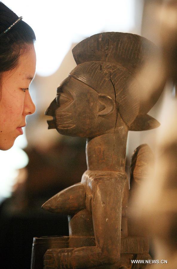 A visitor views a wood sculpture at the African Wood Sculpture Collection exhibition in Nanjing, capital of east China's Jiangsu Province, March 29, 2013. The exhibition kicking off on Friday displays nearly 600 wood carving works from dozens of countries in the sub-Saharan Africa. (Xinhua/Wang Xin) 