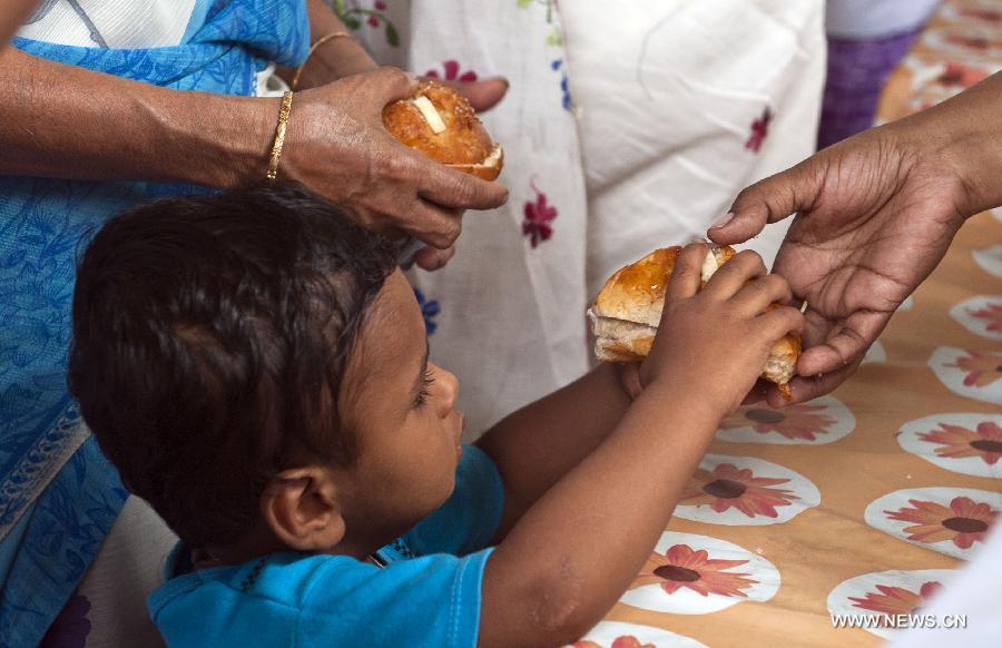 An Indian Christian boy receives an Easter bun during Good Friday celebration at a church in Calcutta, capital of eastern Indian state West Bengal, March 29, 2013. Christians all over the world marked Good Friday, the day when Christ was crucified. (Xinhua/Tumpa Mondal) 