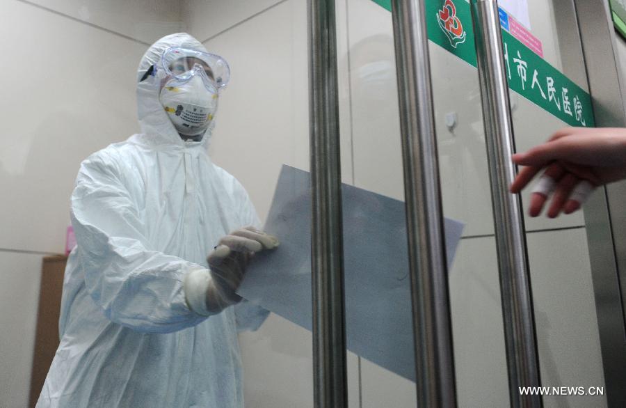 Two medical workers pass the physician's order sheet of a man infected with H7N9, a strain of avian influenza that had never been passed to humans before, at the People's Hospital of Bozhou City, east China's Anhui Province, April 8, 2013. The 55-year-old male patient, surnamed Li, once worked at a local live poultry stall. He was diagnosed positive of the H7N9 avian influenza virus on Sunday. As of 6 p.m. on Monday, China reported 24 cases of human infection with the lesser-known H7N9 bird flu virus, including 11 in Shanghai Municipality, eight in Jiangsu Province, three in Zhejiang Province and two in Anhui Province. Among the seven fatalities, five were in Shanghai and two in Zhejiang. (Xinhua/Liu Junxi)