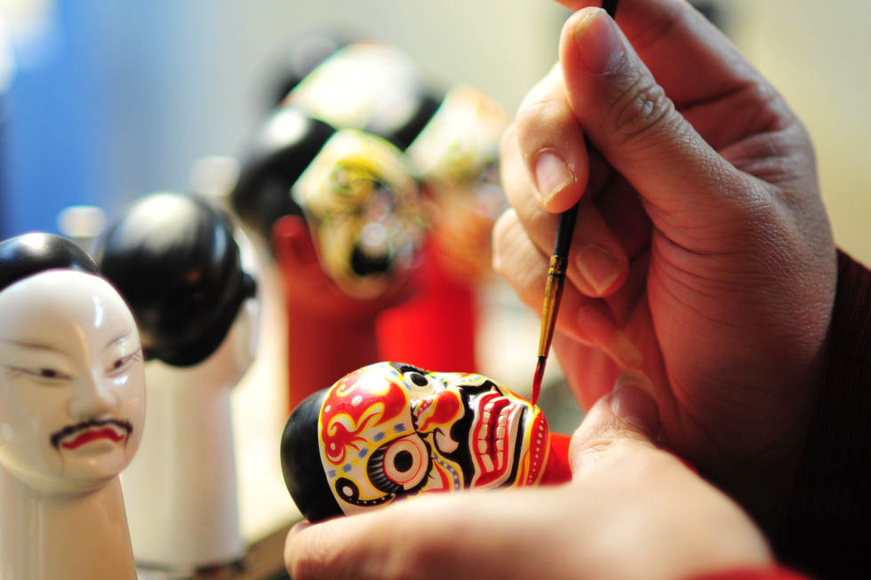 Huang Qinghui paints the head of a wood puppet. He has been pursuing his puppet dream for almost three decades. (Xinhua Photo/ Wei Peiquan)