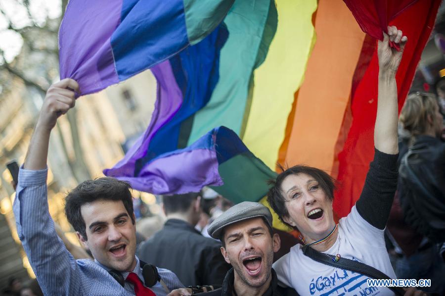 Supporters celebrate after France's legislators give the green light to same-sex couples to marry and adopt children in Paris, April 23, 2013. As the ruling Socialist Party (PS) enjoys an absolute majority at the National Assembly where 331 legislators voted for the bill and 225 voted against, it successfully paved the way for France to join dozens of other countries, mostly in Europe, to allow same-sex unions and adoption.(Xinhua/Etienne Laurent) 