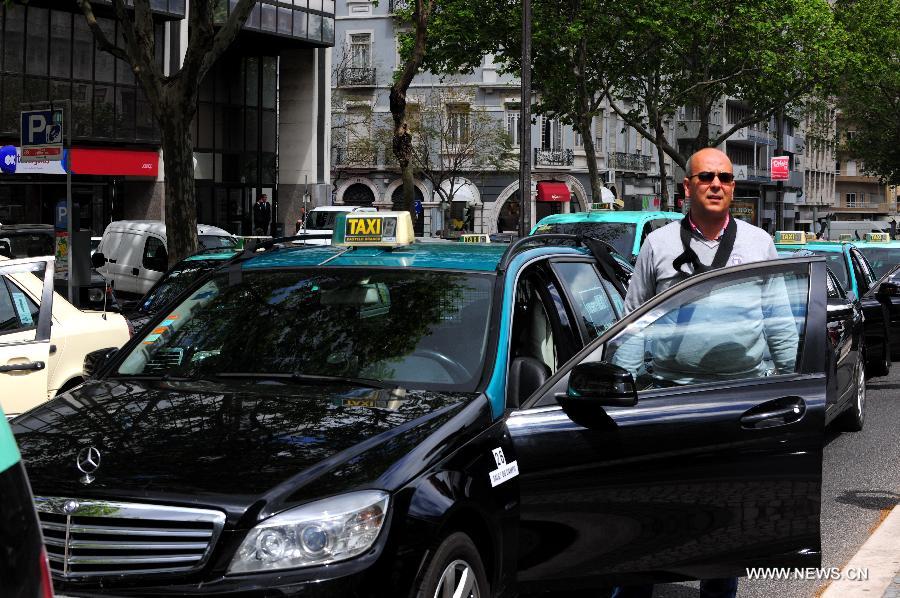 Taxis are seen on the street in Lisbon, Portugal, on April 29, 2013. Thousands of Portuguese taxi drivers drove their car into Lisbon on Monday in protest against government's decision to shift the transportation of non-emergency patients by them to firefighting department. (Xinhua/Zhang Liyun)  