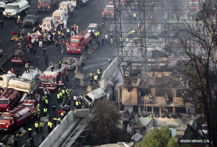 Firemen and Police work at the site of an explosion on the Mexico-Pachuca highway in Ecatepec, Mexico, on May 7, 2013. At least 18 people were killed and dozens of others injured when a gas tanker exploded early Tuesday in a Mexico City suburb, authorities said. (Xinhua/Susana Martinez) 