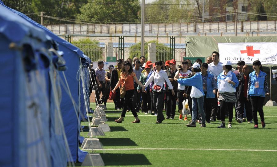 People enter the temporary settlement during a disaster relief drill in Beijing, capital of China, May 10, 2013, two day ahead of the Disaster Prevention and Reduction Day. The Disaster Prevention and Reduction Day was set in 2009, after a devastating earthquake hit Sichuan and neighboring Gansu and Shaanxi provinces on May 12, 2008, leaving 87,000 people dead or missing. (Xinhua/Li Xin) 