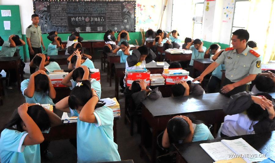 Middle school students participate in an earthquake relief drill in Jinghong City of Xishuangbanna Dai Autonomous Region, southwest China's Yunnan Province, May 12, 2013, the country's Disaster Prevention and Reduction Day. (Xinhua/Chen Haining) 