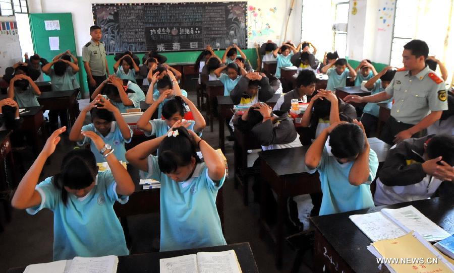 Middle school students participate in an earthquake relief drill in Jinghong City of Xishuangbanna Dai Autonomous Region, southwest China's Yunnan Province, May 12, 2013, the country's Disaster Prevention and Reduction Day. (Xinhua/Chen Haining) 