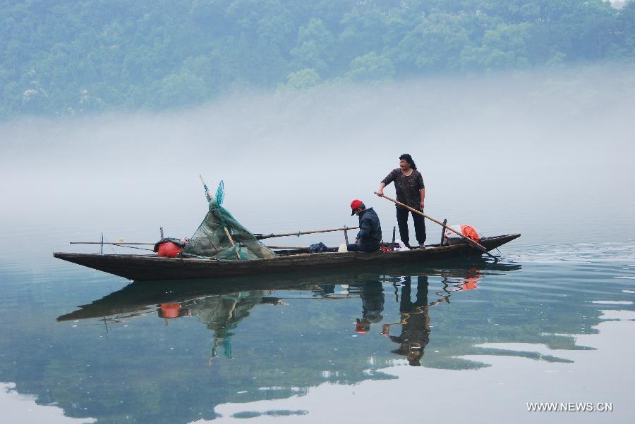 Fisherman steer a boat through fogs on the Xin'an River in Jiande, east China's Zhejiang Province, May 15, 2013. (Xinhua/Ning Wenwu) 