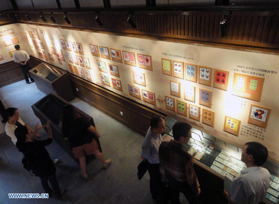 Visitors appreciate zodiac stamps in the Suzhou Zodiac Stamp Museum in Suzhou, east China's Jiangsu Province, May 15, 2013. The museum, which will be opened to the public free of charge on May 18, stores zodiac stamps which were issued in more than 100 countries and regions since 1950. (Xinhua/Wang Jiankang)