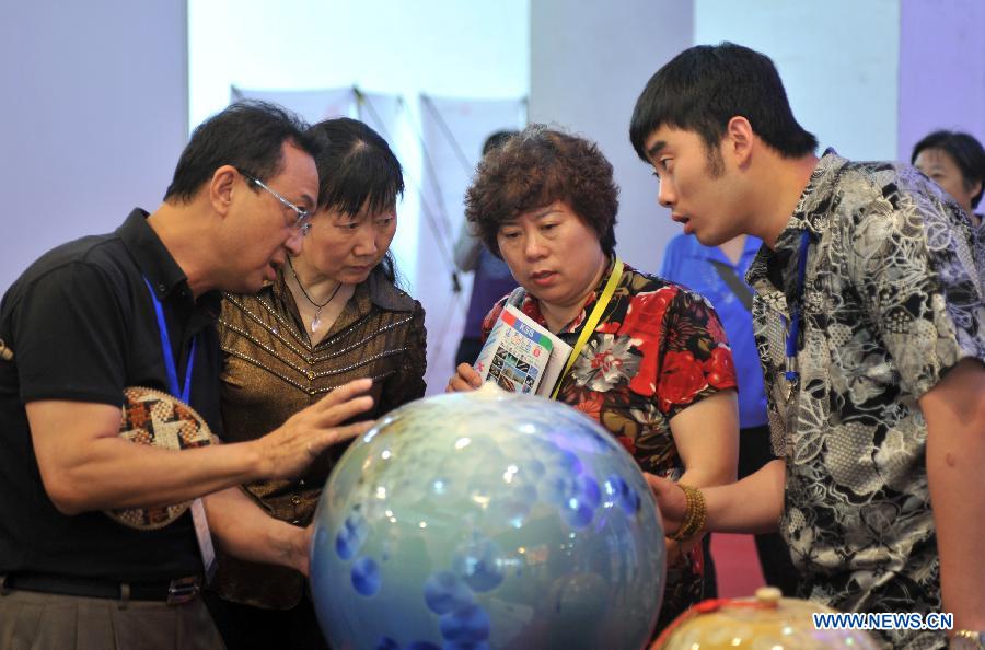 An exhibitor introduces products to visitors at the 2013 Taiwan Trade Fair in Shijiazhuang, capital of north China's Hebei Province, May 16, 2013. The four-day fair attracting more than 180 enterprises from southeast China's Taiwan kicked off here on Thursday. (Xinhua/Zhu Xudong)