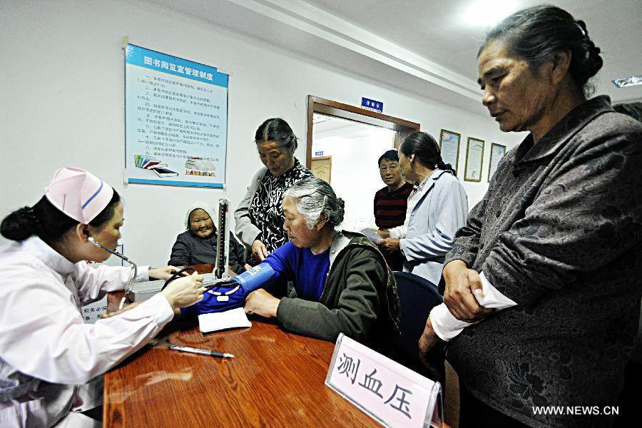 A medical worker tests the blood pressure of a patient in Daishan County, Zhoushan City, east China's Zhejiang Province, May 17, 2013. A medical service team, formed by medical workers from the Zhoushan detachment of the provincial Frontier Defence Department and some doctors from the local Red Cross Society, provided free medical treatments to residents here on Friday. (Xinhua/Xu Yu)  