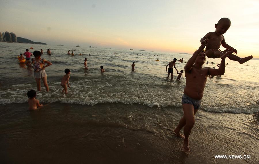 People play along the seaside in Sanya, south China's Hainan Province, May 20, 2013. (Xinhua/Chen Wenwu) 