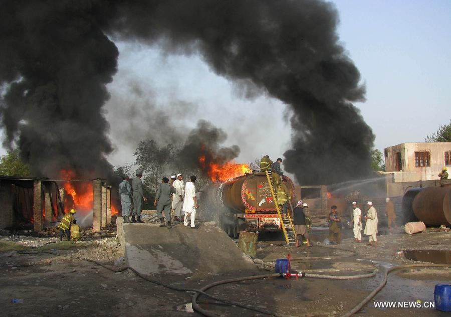 Firefighters work to extinguish fire at a parking lot where five oil trucks caught fire in Jalalabad, capital city of eastern Afghan province of Nangarhar on May 20, 2013. At least one person was killed in the fire on Monday afternoon. Police officials ruled out involvement of militants in the incident. (Xinhua/Tahir Safi)