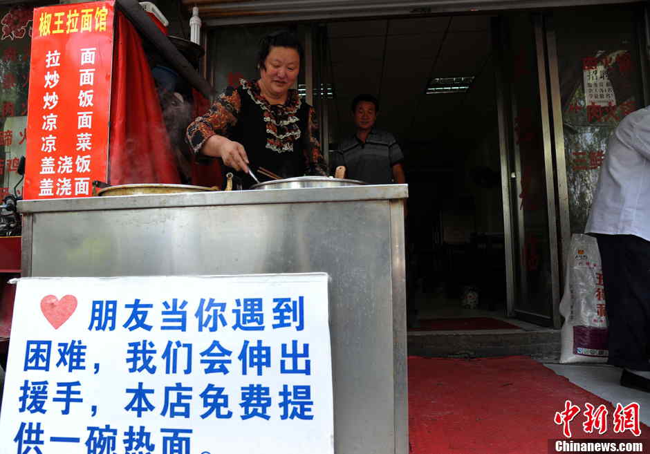 The shop owner serves a bowl of hot noodles for diner in Hefei, the capital city of central China's Anhui province on May 21, 2013. (Photo by Han Suyuan/ Chinanews.com)