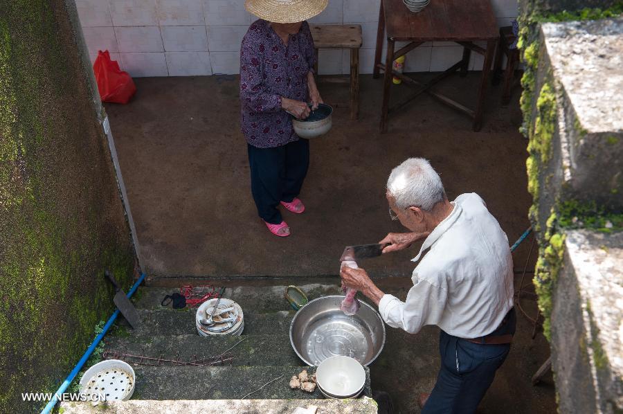 Qiu Xianghai (R), 84, and his wife Lai Guixiang, 82, prepare for cooking in Hongxing Village of Jiaoling County, Meizhou City, South China's Guangdong Province, May 23, 2013. The couple has a son suffering from mental diseases and a daughter who lives far away from their house, leaving them self-dependent after the rainstorm hitting Guangdong Province on May 18. With the youth attending school or working outside their hometowns, the left-behind family members are becoming even more vulnerable after natural disasters. (Xinhua/Mao Siqian) 