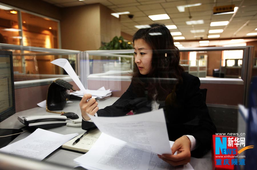 Chen Shan checks the collected materials and does financial assessment for an enterprise. (Photo/Xinhua)