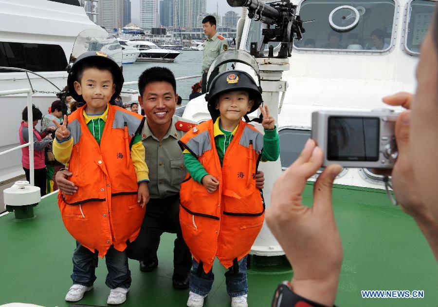 Children visit a patrol boat during an open day of local frontier defense vessel division in Qingdao, a coastal city in east China's Shandong Province, May 28, 2013. (Xinhua/Li Ziheng)