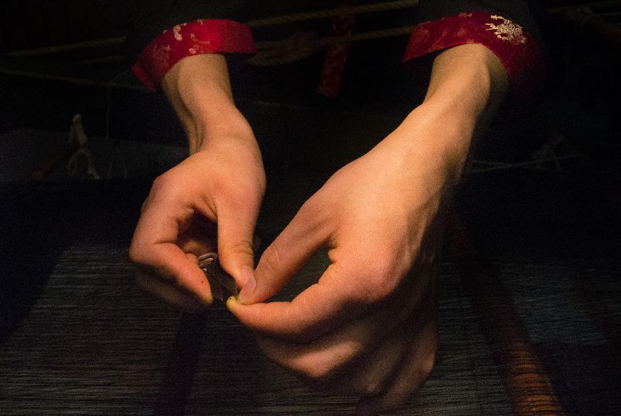 A weaver weaves Shu brocade, a traditional artwork in southwest China's Sichuan Province, with a loom, in Chengdu, capital of Sichuan, May 27, 2013. Imparted from generation to generation for over 2,000 years, Shu brocade weaving techniques have been put on China's Intangible Cultural Heritage List in 2006. (Xinhua/Li Qiaoqiao) 