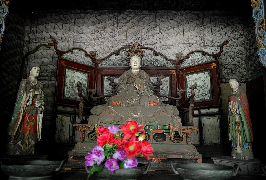 Photo taken on May 24, 2013 shows colored sculptures at the Shengmu Dian (Hall of the Saint Mother) of Jinci Temple in Taiyuan, capital of north China's Shanxi Province. Jinci Temple was first built during the period of the Northern Wei (386-534) in commemoration of Shuyu, the second son of Emperor Wuwang of the Zhou dynasty (1100-771 BC). Shengmu Dian is the principal hall in the temple, built to honor the mother of Shuyu, featuring 42 various sculptures of maids. (Xinhua/Yan Yan) 