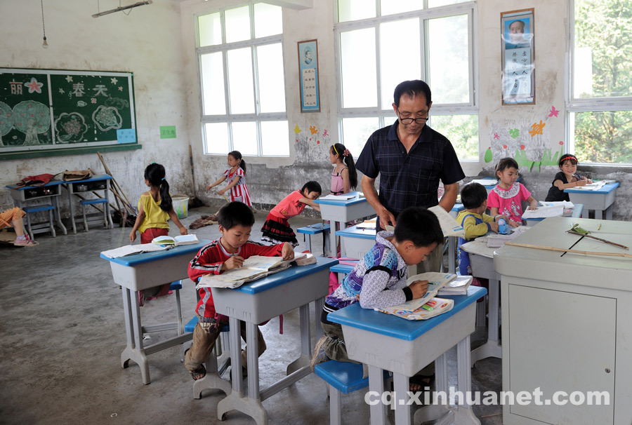 A teacher helps the students with their homework. 90 percent of students in Shijiao Yingshan School are left-behind children separated from their parents who seek jobs in big cities. (Photo by Huang Junhui/ cq.xinhuanet.com)