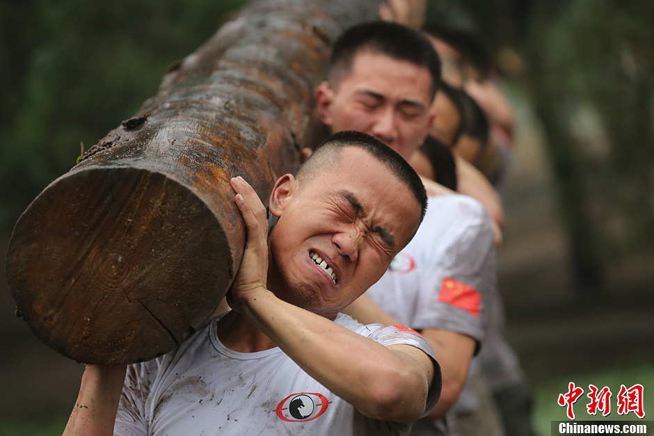 Trainees lift a log during a VIP security training course at the Genghis Security Academy in Beijing, June 6, 2013. More than 70 trainees, including six women and three foreigners will receive high-intensity training for VIP security at a bodyguard camp in Beijing. They will train over 20 hours per day for one week. One third of the participants will be phased out at the end of the "Hell Week".  (Photo/ Chinanews.com)