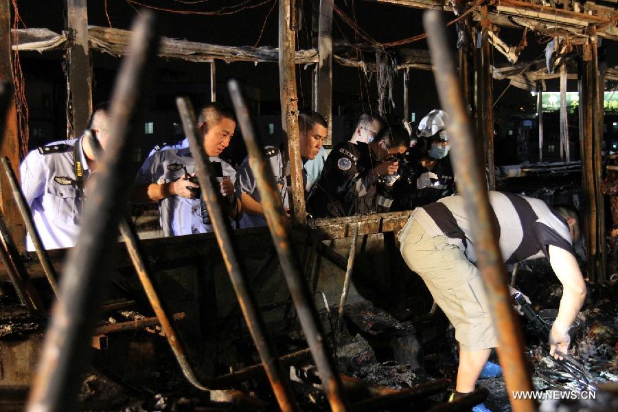 Investigators work inside the debris of a burned bus in Xiamen, southeast China's Fujian Province, early June 8, 2013. The bus fire happening in Xiamen on Friday evening has claimed 47 lives and hospitalized 34 passgengers. An old man who allegedly set fire to the crowded bus to "vent personal grievances" had died in the blaze, local authorities said Saturday. Chen Shuizong, born in 1954 and a native of Xiamen, was identified as the arsonist of the fire. (Xinhua)