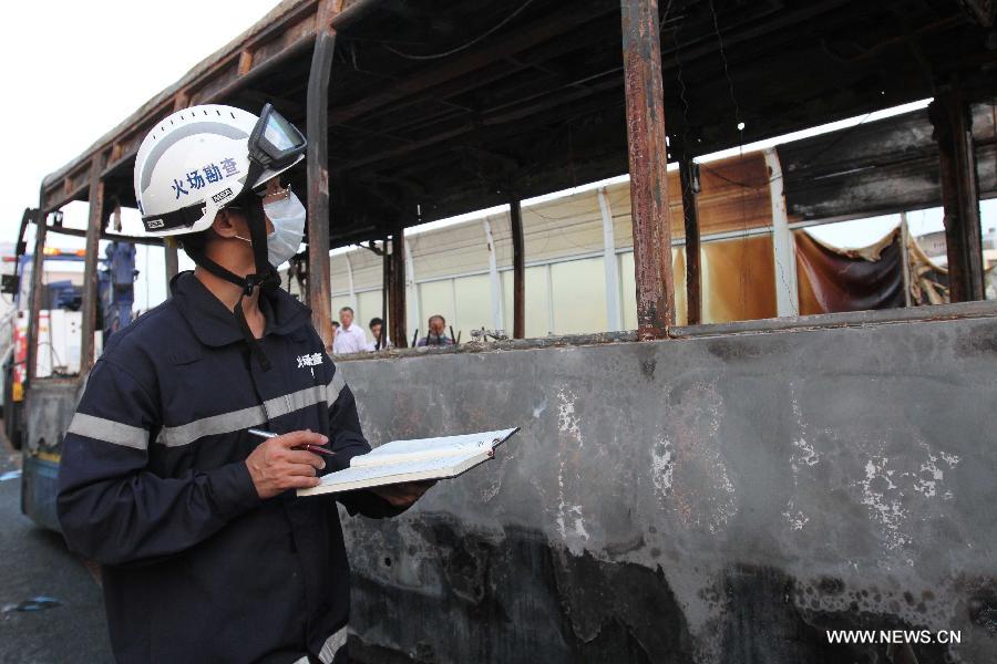 Investigators work inside the debris of a burned bus in Xiamen, southeast China's Fujian Province, early June 8, 2013. The bus fire happening in Xiamen on Friday evening has claimed 47 lives and hospitalized 34 passgengers. An old man who allegedly set fire to the crowded bus to "vent personal grievances" had died in the blaze, local authorities said Saturday. Chen Shuizong, born in 1954 and a native of Xiamen, was identified as the arsonist of the fire. (Xinhua)