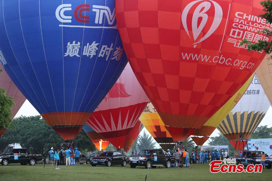 Contestants prepare for an air balloon competition in Evergreen Garden in Haikou, South China's Hainan Province, June 18, 2013. The air balloon competition kicked off on Tuesday, in which contestants are requested to fly across the Qiongzhou Strait from Haikou and reach a designated place in Xunwen County in the neighboring Guangdong Province. (CNS/Wang Xinli)