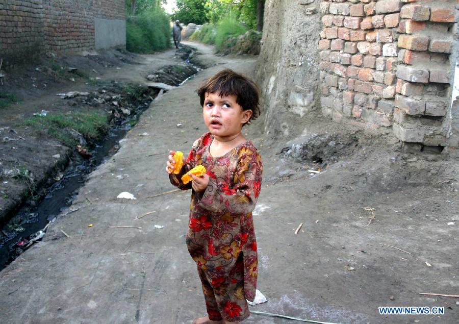 An Afghan refugee girl eats corn on the outskirts of Peshawar, a city in northwest Pakistan on June 19, 2013, on the eve of World Refugee Day. There are 1.65 million registered Afghans currently living in Pakistan. Since 2002, UNHCR's voluntary repatriation program has helped more than 3.8 million Afghan refugees return home. (Xinhua Photo/Ahmad Sidique)