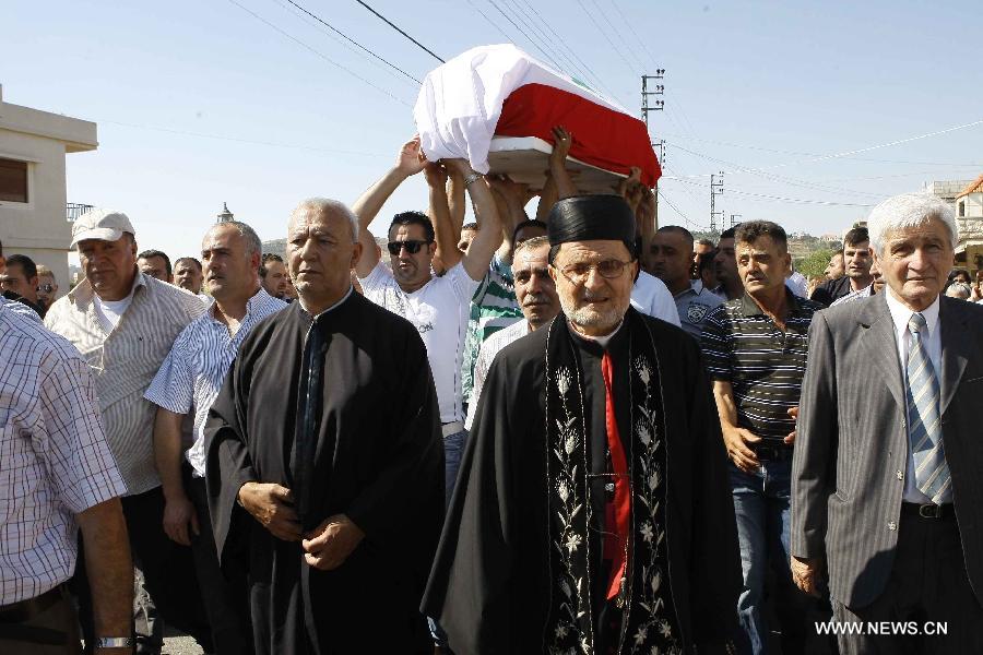 Mourners take part in the funeral of a Lebanese soldier, who was killed during clashes between the Lebanese army and Sunni radicals, in the country's southern town of Rmeish on June 24, 2013. Twelve soldiers were killed and 50 others injured on Monday when Lebanese army was trying to arrest Salafist cleric Sheikh Ahmed Al Assir in the southern city of Sidon. (Xinhua) 