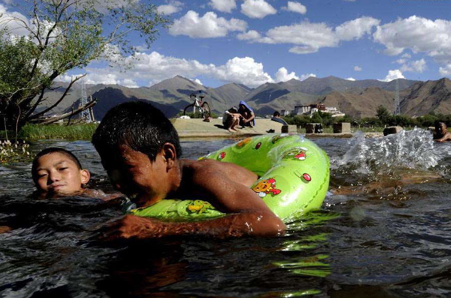 Young men cool themselves off in a river in suburban Lhasa, capital of southwest China's Tibet autonomous region, June 17, 2013. (Photo/Xinhua)