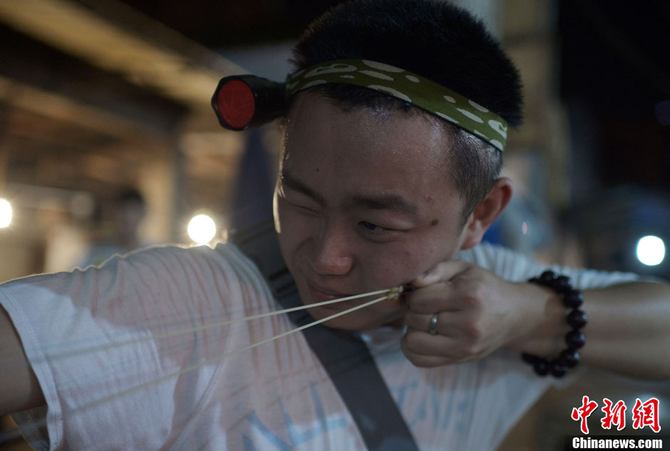 A hunter wearing torch on head and holding catapult targets a rat. (Photo/ CNS)