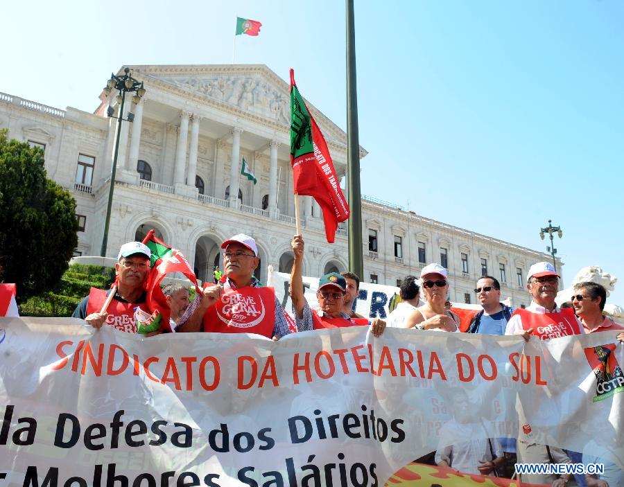 People pass by a closed metro station in Lisbon, June 27, 2013. The Portuguese staged a general strike across the country on Thursday fuelled by the prolonged economic recession in the bailed-out country. Meanwhile, thousands of Portuguese in Lisbon took to the street protesting against the government's austerity measures. (Xinhua/Zhang Liyun) 