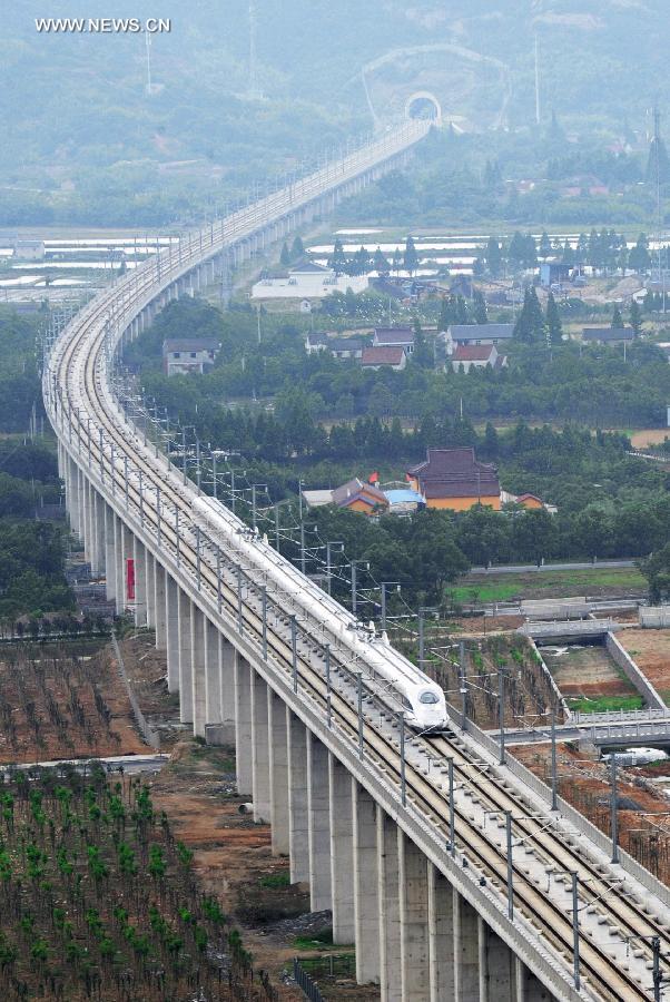 Photo taken on May 24, 2013 shows a bullet train on its trial trip in Huzhou City, east China's Zhejiang Province. A new high-speed railway that stretches across east China's Yangtze River Delta is scheduled to go into commercial service on July 1. The Nanjing-Hangzhou-Ningbo high-speed railway, with a designated top speed of 350 km per hour, will cut travel time between Nanjing, capital of east China's Jiangsu Province, and the port city of Ningbo in east China's Zhejiang Province to about two hours. High-speed trains will run at a speed of 300 km per hour during the initial operation period. (Xinhua/Tan Jin)