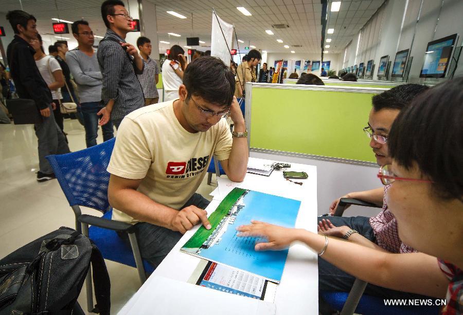 Mubeen Abdul (L), a student from Pakistan, talks with recruiters in a job fair in Chongchuan District in Nantong, east China's Jiangsu Province, June 29, 2013. Mubeen is a fresh graduate seeking for a job in Nantong from Nantong University, majoring in clinical medicine. He rent a house and attended many job fairs in a month. No answer from employers and low income from part-time job exert much pressure on him. Finally he got a job for reception of foreign guests and management in Nantong First People's Hospital on July 1, 2013. "I love China and Iwill continue studying for master's degree and qualification of medical practitioners," said Mubeen. (Xinhua/Huang Zhe)