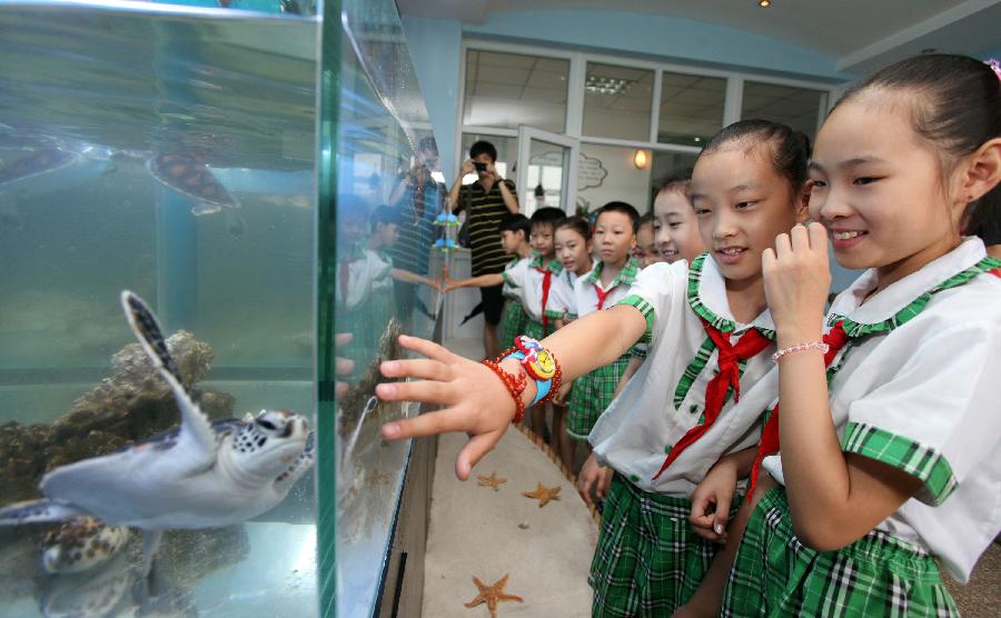 Children visit polar aquarium in the Hongqiao District Experimental Primary School in north China's Tianjin Municipality, July 8, 2013. The Hongqiao District Experimental Primary School Polar Aquarium, the first of its kind in Tianjin, opened on Monday. (Xinhua/Liu Dongyue)