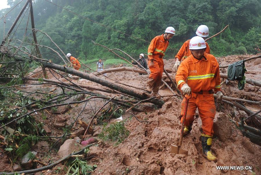 Fire fighters walk on muds while searching for survivors at the Sanxi Village, in Dujiangyan City, southwest China's Sichuan Province, July 11, 2013. As of 2:10 p.m. Thursday, rescuers had found 18 bodies from the landslide that happened on Wednesday morning in the village of Sanxi. (Xinhua/Xue Yubin)