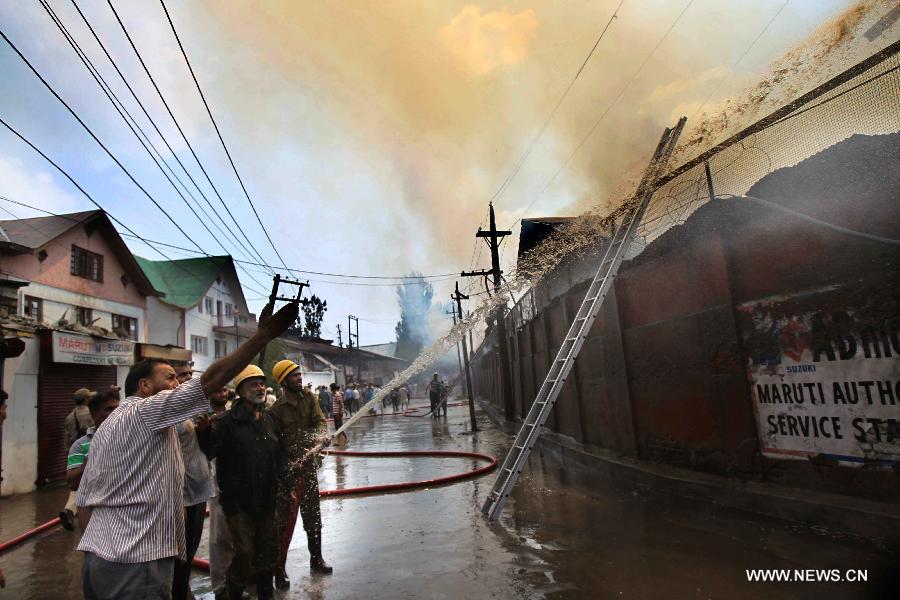 Firefighters try to distinguish the fire in a building on the premises of Civil Secretariat in Srinagar, the summer capital of Indian-controlled Kashmir, July 11, 2013. Massive fire broke out Thursday in a building on the premises of Civil Secretariat in Srinagar, the summer capital of Indian-controlled Kashmir, officials said. (Xinhua/Javed Dar)