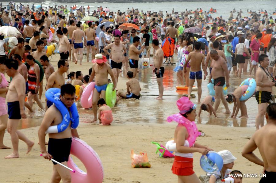 Tourists enjoy coolness at the Dashawan bathing beach in Lianyungang, east China's Jiangsu Province, July 13, 2013. Saturday marks the beginning of the hottest part of summer. Many people came to the seashore to spend a cool weekend. (Xinhua/Wang Chun) 